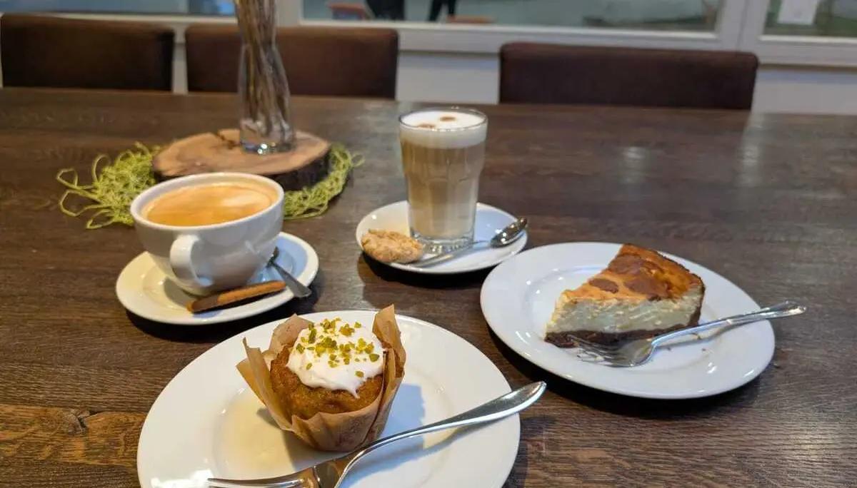 Auf einem Tisch stehen Tassen mit Kaffee und Teller mit Kuchen | © Kletterzentrum
