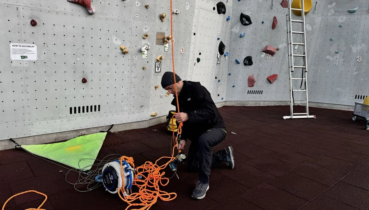 Ein Mann vor der Kletterwand mit Seil  | © Kletterzentrum