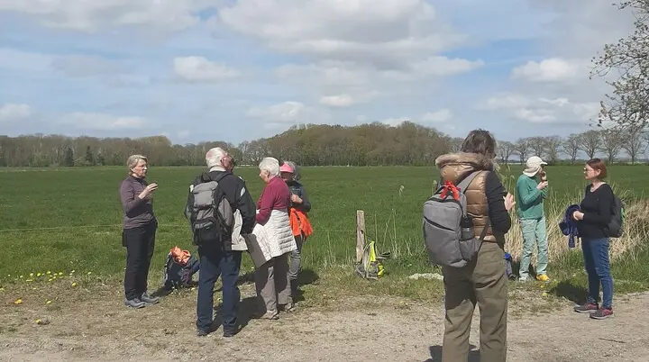 Wandergruppe bei der Rast, im Hintergrund Wiese | © Beate Straube